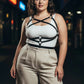 Plus-size black leather harness-style body accessory by HarnessClub worn over a white top