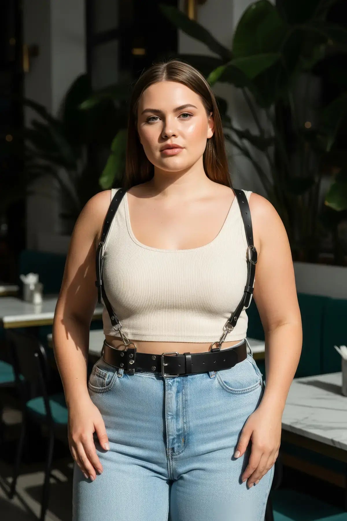 Plus-size black leather harness with O-ring hardware worn as a body accessory