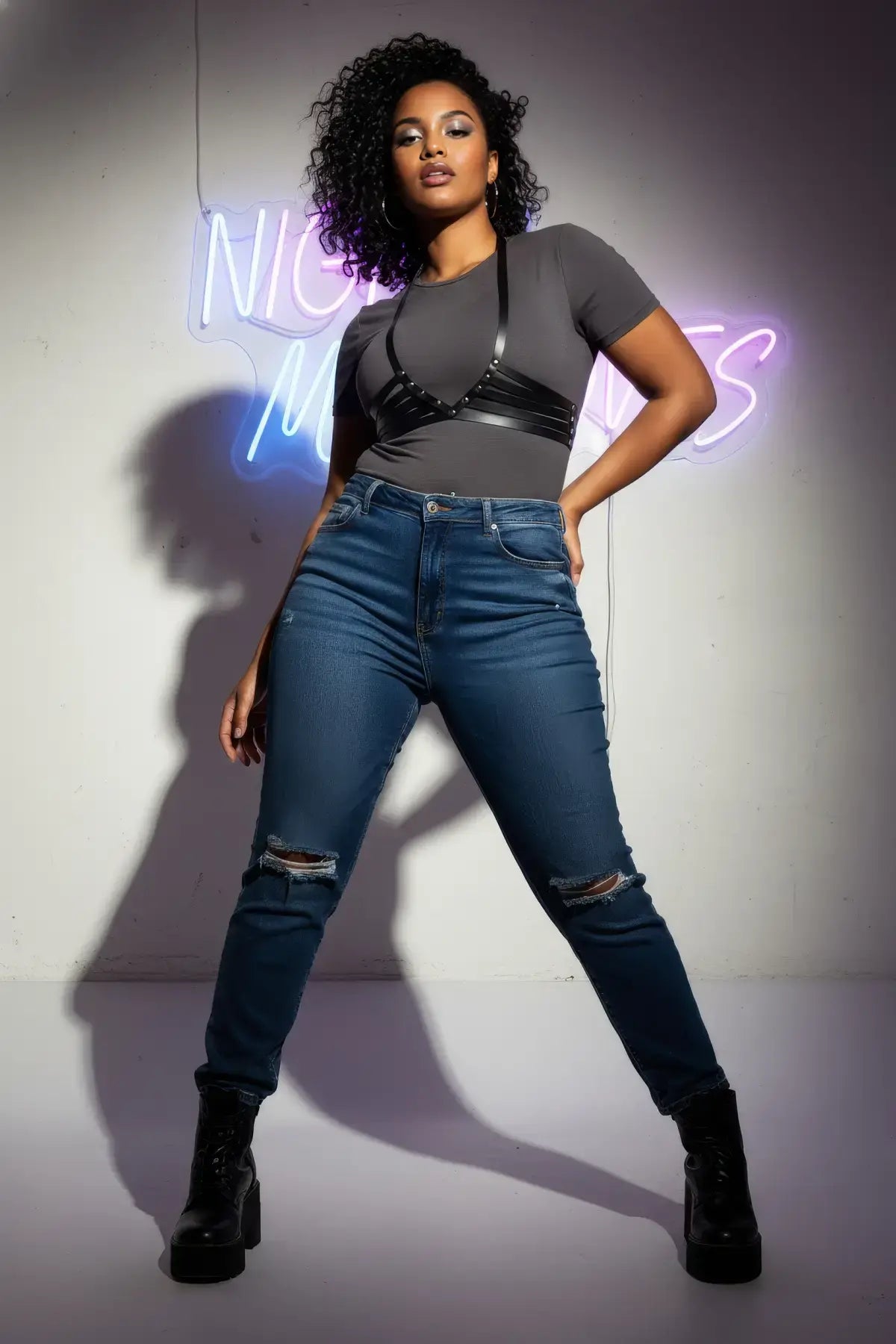 Plus-size black horizontal-strap corset harness by HarnessClub, vegan leather worn by model over gray tee.