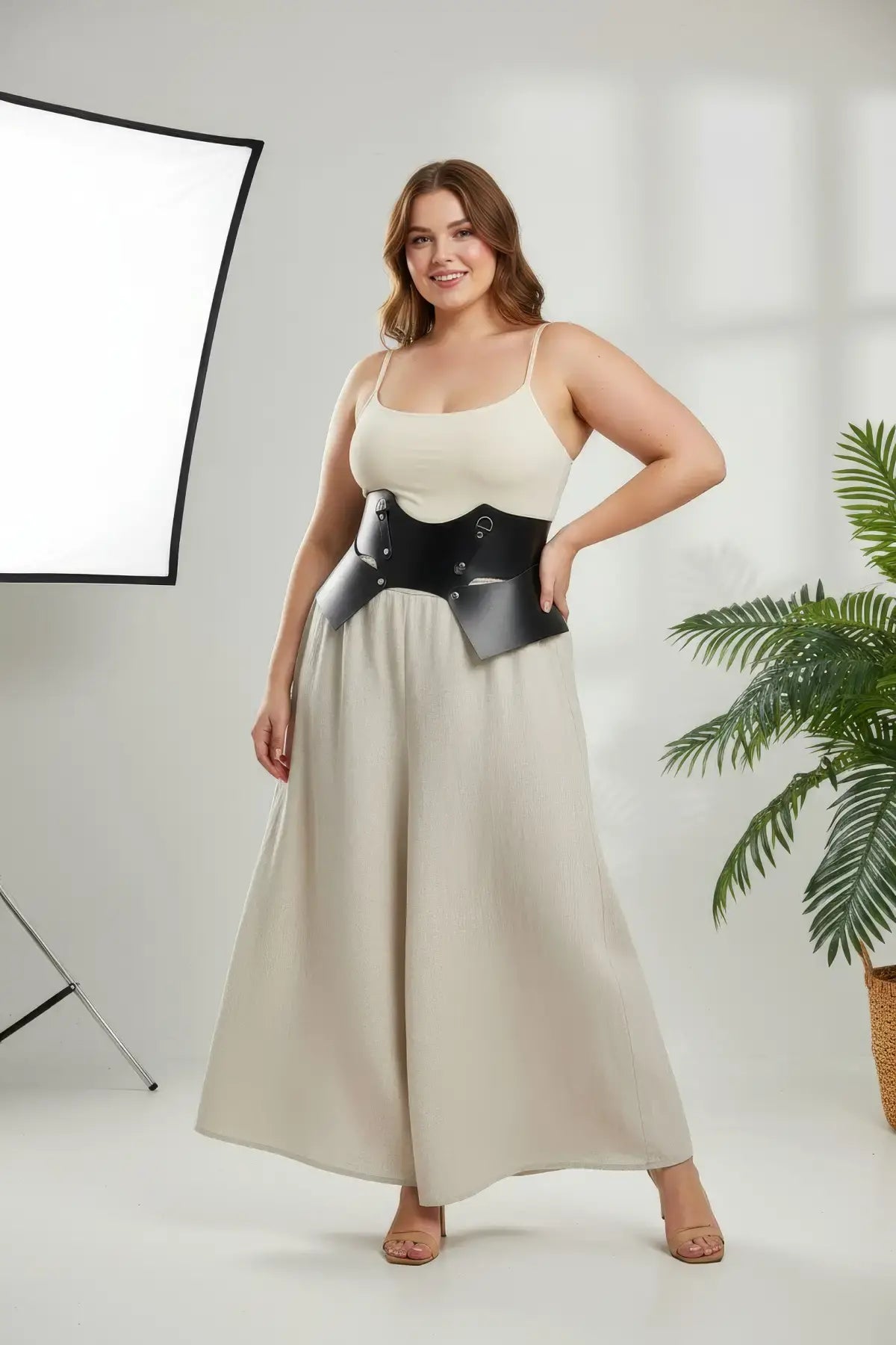 Plus-size black vegan leather lace-up corset belt worn as a structured waist harness.