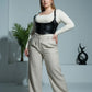 Plus Size Black Lace-Up Corset Harness by HarnessClub in vegan leather worn over white top and beige trousers