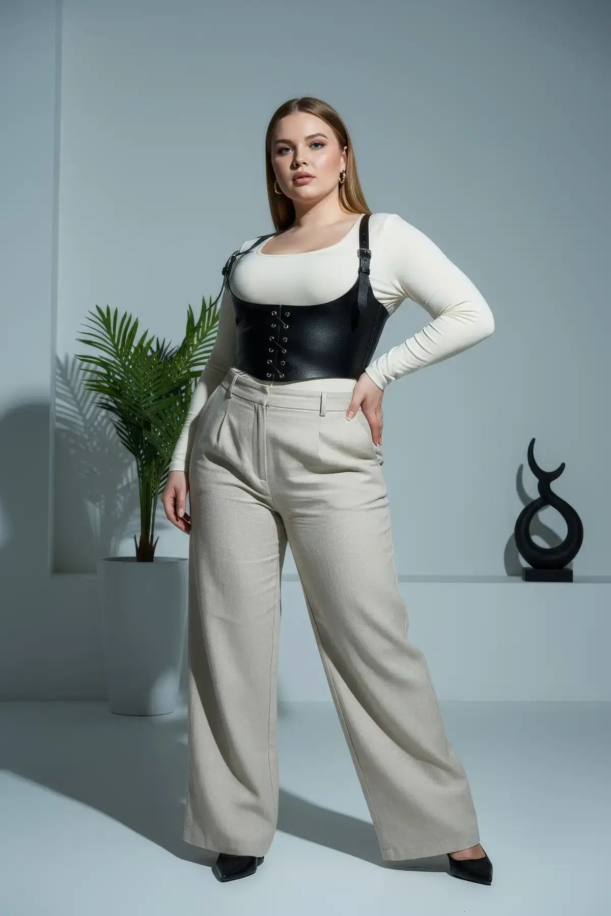 Plus Size Black Lace-Up Corset Harness by HarnessClub in vegan leather worn over white top and beige trousers