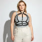 Plus-size black leather lace-up corset-style harness with strappy design worn over gray top by HarnessClub