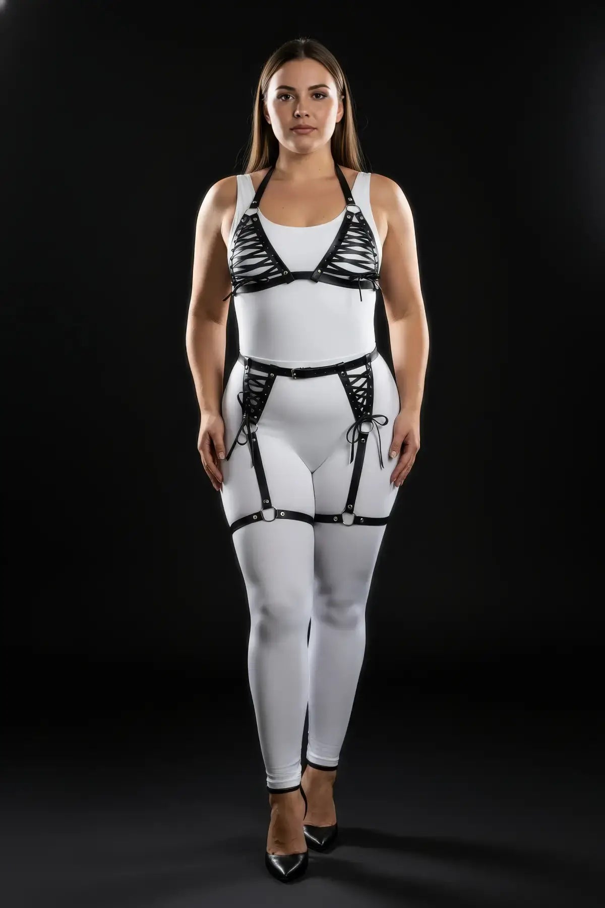 Plus-size black lace-up leather harness set with garter belt worn over white bodysuit