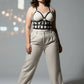 Plus size black leather body harness outfit completer worn over a white ribbed top and beige trousers