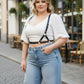 Plus Size Black Leather Harness Body Accessory worn by a woman in a white top and jeans, with metal rings.