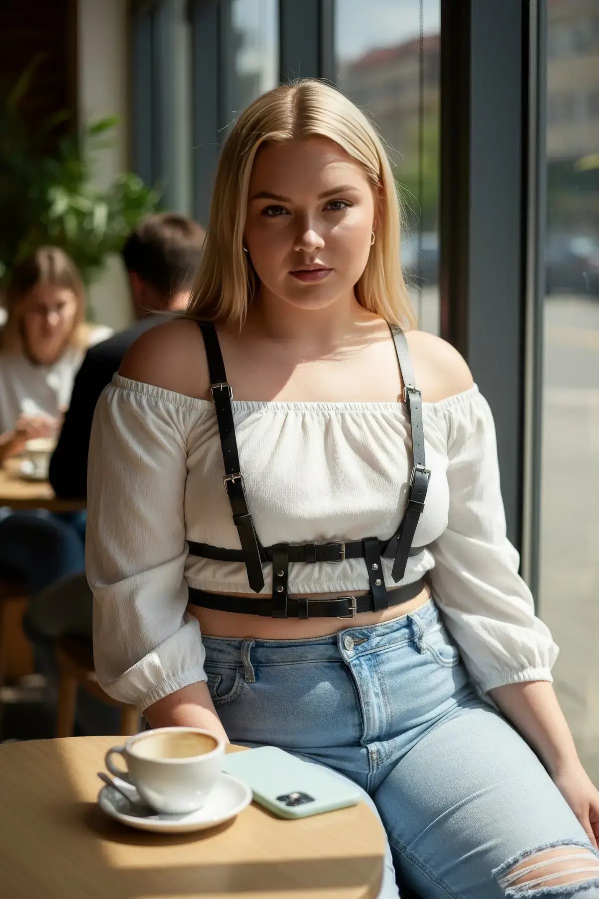 Plus-size black leather harness-look adjustable body accessory worn over a white off-shoulder top