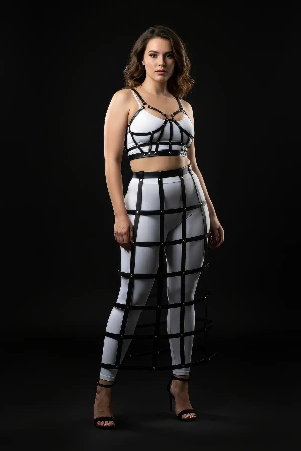 Plus-size black vegan-leather long cage skirt and chest harness set (two-piece) shown on model.