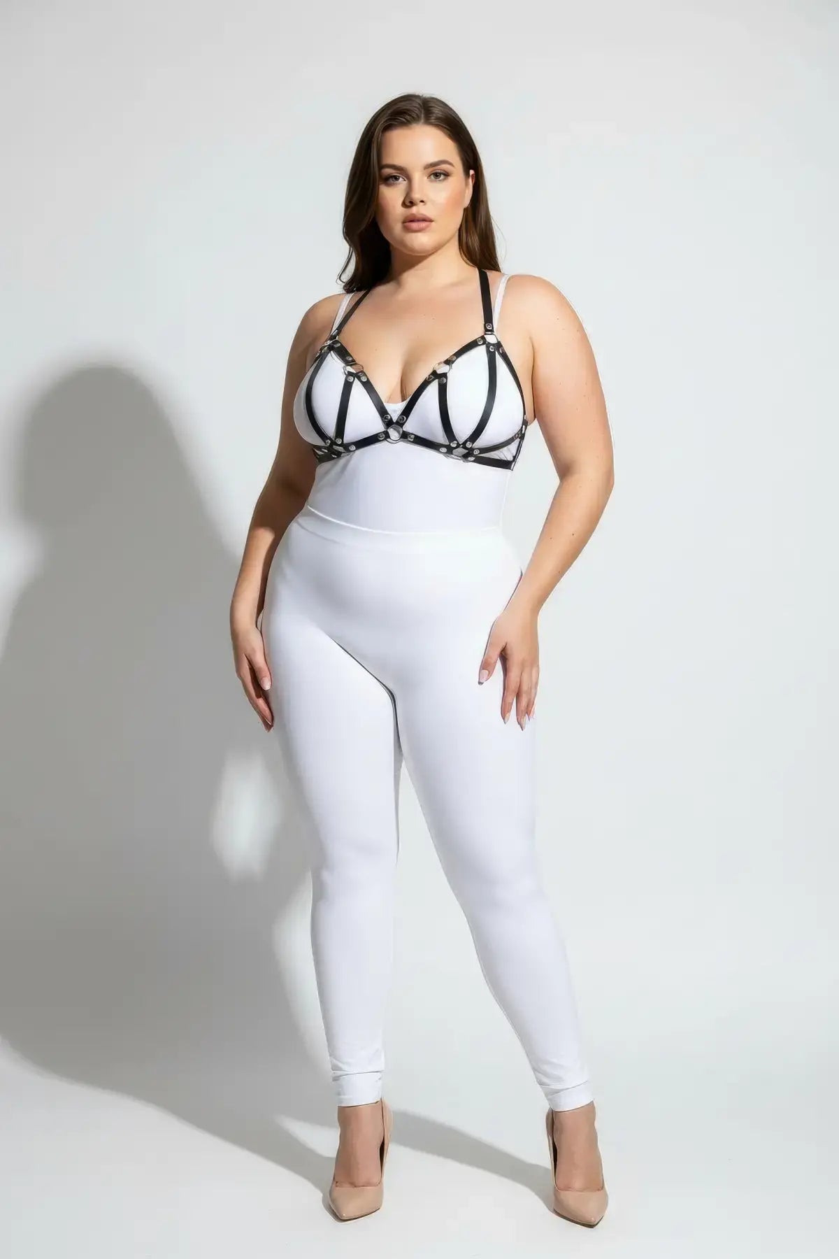 HarnessClub plus-size black vegan leather M-strap bra harness with studs worn over white bodysuit