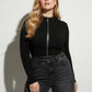 Plus-size black micro-stud collar and waist harness by HarnessClub in vegan leather, worn over a black top.