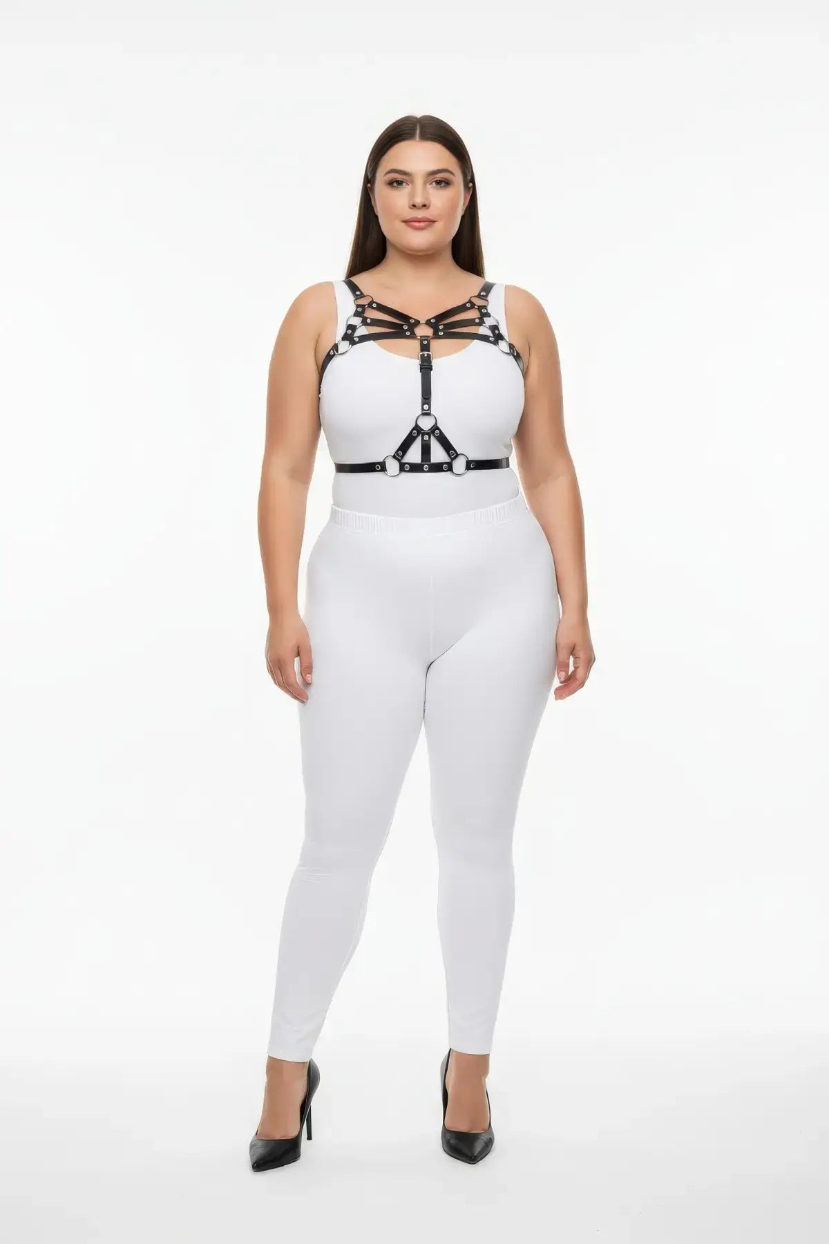 Plus-size black vegan-leather multi-band O-ring chest harness worn over a white top.