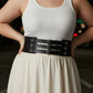 Plus-size black wide corset belt with three buckles worn at the waist over a white tank top.