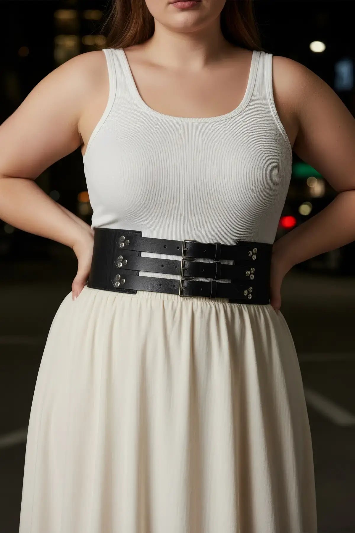 Plus-size black wide corset belt with three buckles worn at the waist over a white tank top.