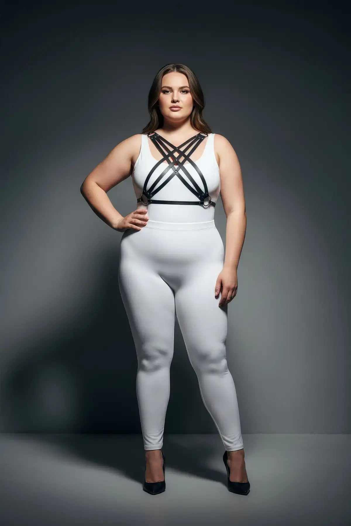 Plus size black multi-cross cage chest harness by HarnessClub, vegan leather, worn over a white bodysuit.