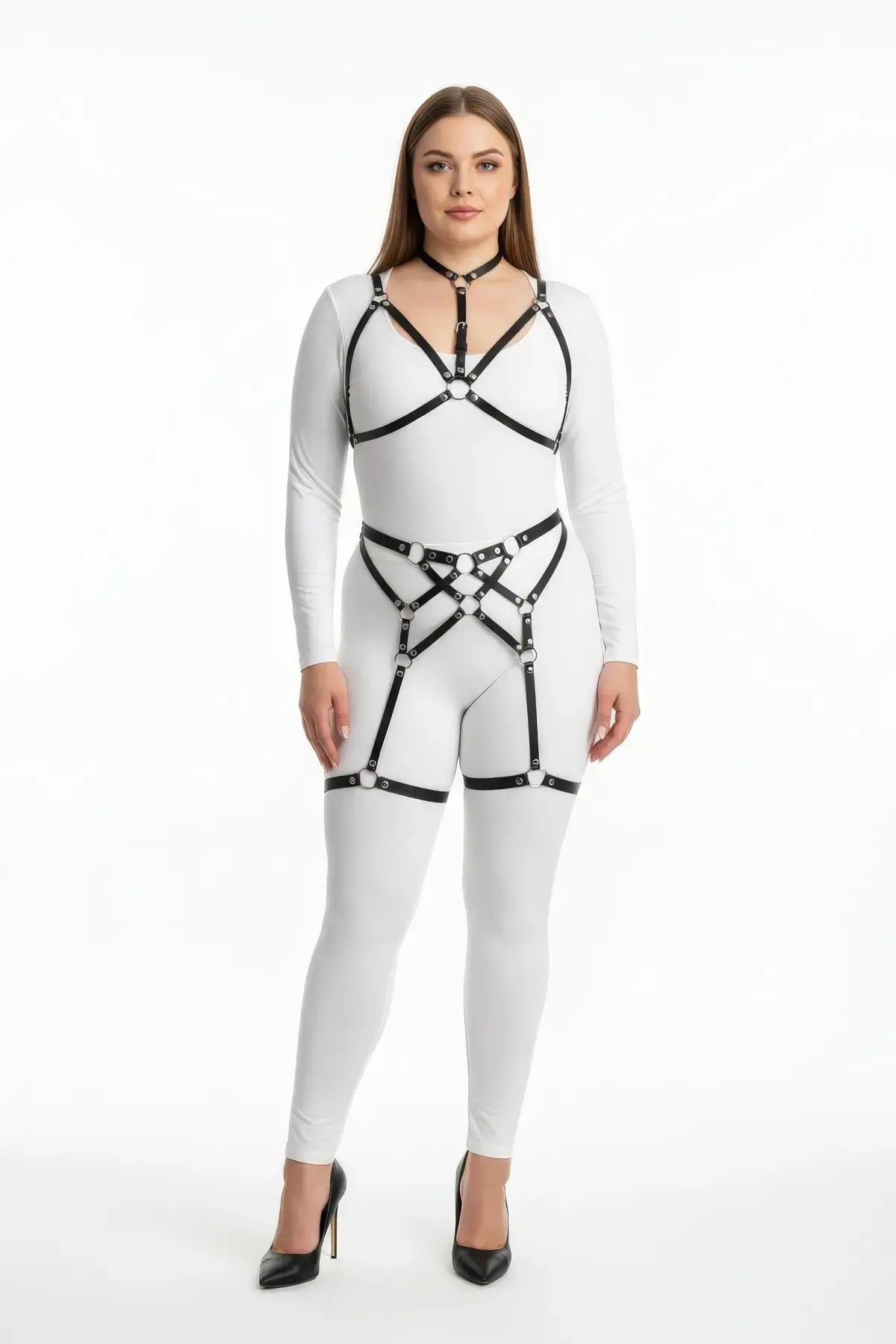Plus-size black vegan-leather multi-ring garter full-body harness set worn over a white bodysuit.