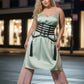 HarnessClub plus-size black vegan-leather multi-strap corset belt with tassels over pale green satin dress