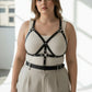 Plus Size Black Multi-Strap Leather Body Harness by HarnessClub worn over a beige tank top