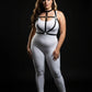 Plus-size HarnessClub black vegan leather O-ring collar and cage chest harness worn over white bodysuit for bold look.