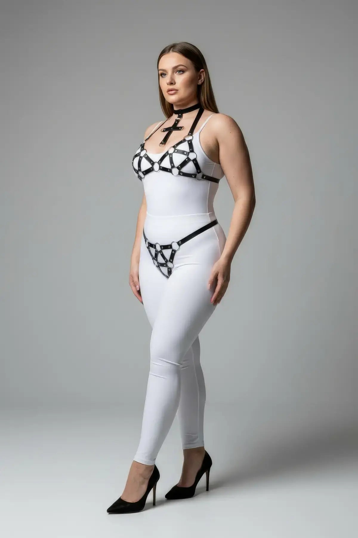 Plus Size Black O-Ring Faux Leather Body Harness by HarnessClub worn over a white bodysuit