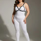 Plus-size black faux-leather O-ring bra harness by HarnessClub worn over a white bodysuit.