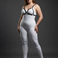 Plus size black faux-leather O-ring bra harness worn over a white bodysuit.