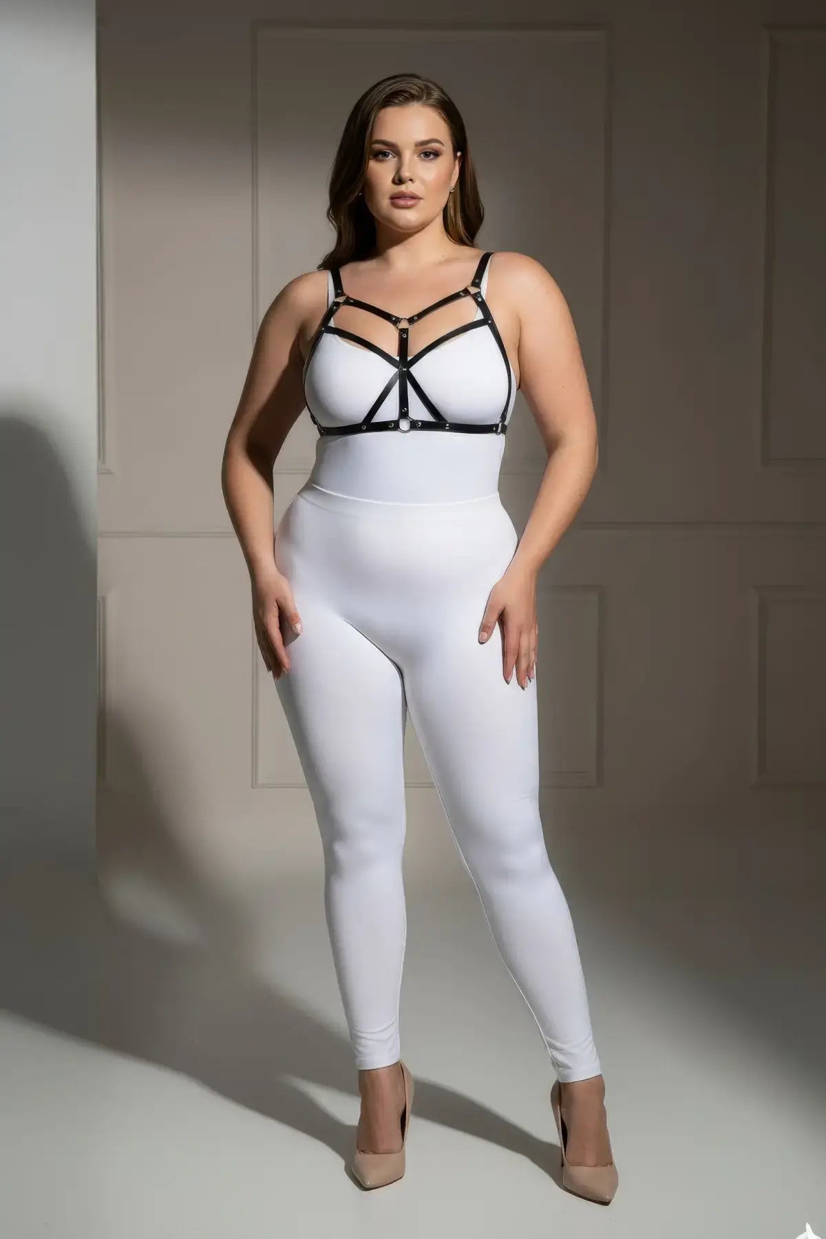 Plus-size black faux-leather O-ring harness set over a white bodysuit; HarnessClub body accessory
