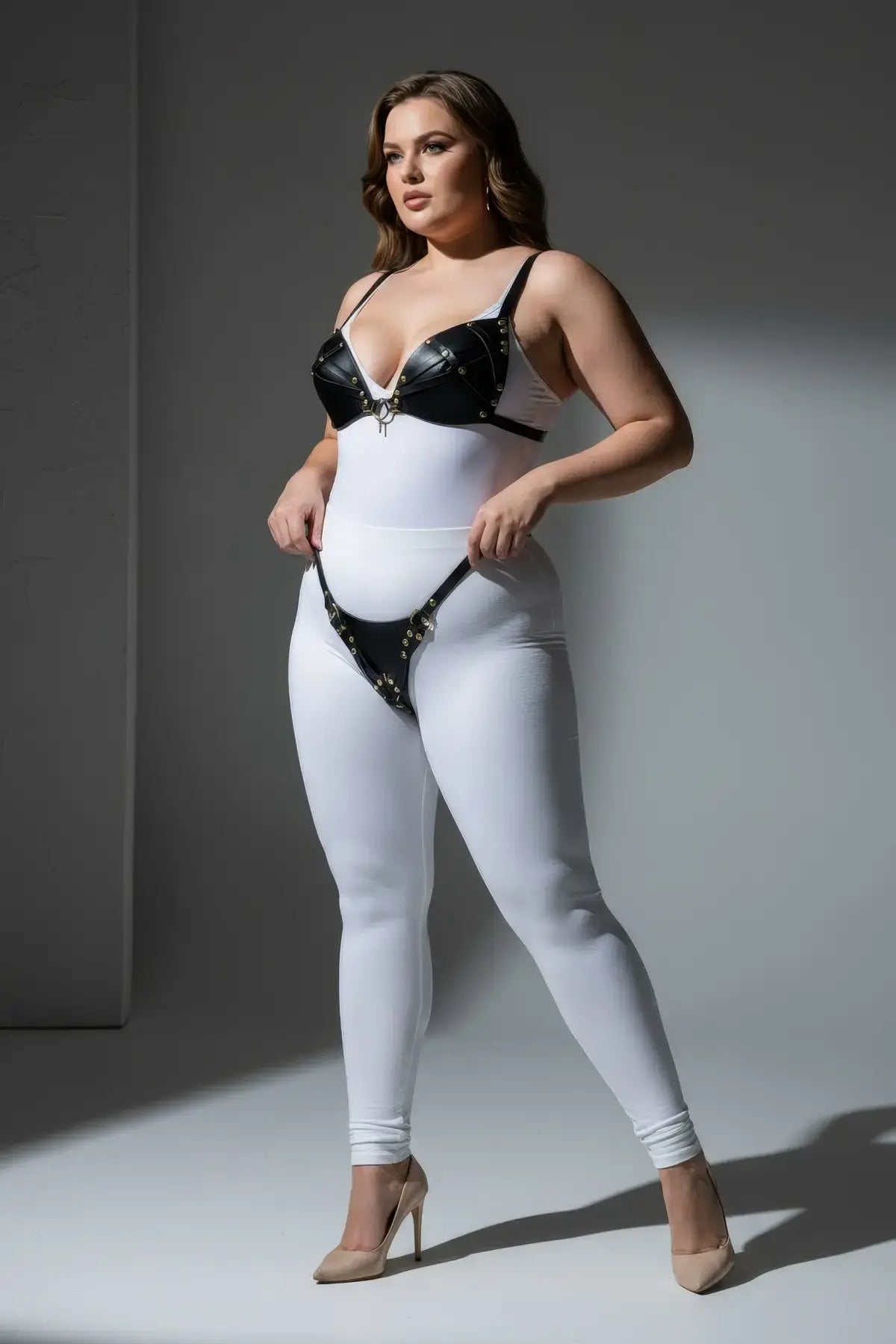 Plus-size black faux-leather O-ring harness set by HarnessClub, worn with white bodysuit