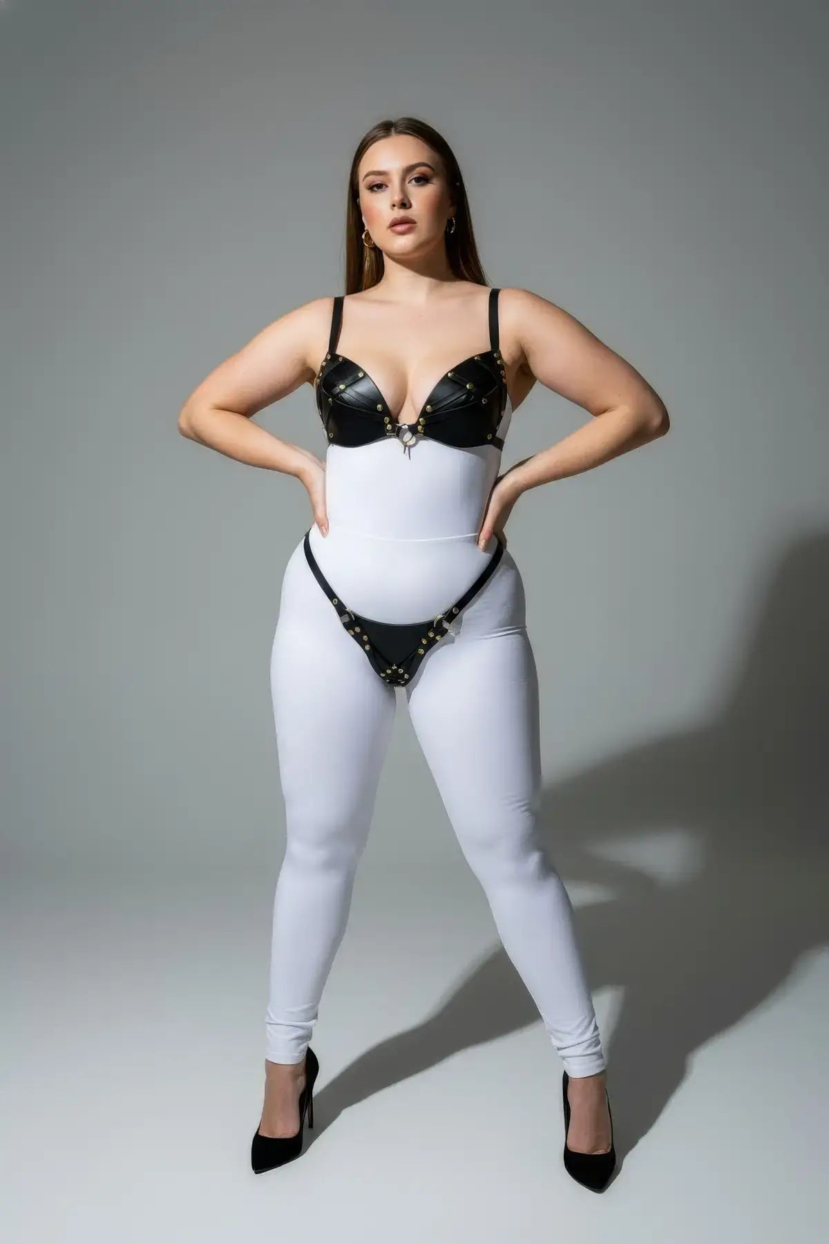 Plus-size black faux-leather O-ring harness set with studded bra top and matching waist belt
