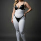 Plus-size black o-ring faux leather harness set by HarnessClub, worn over a white bodysuit.