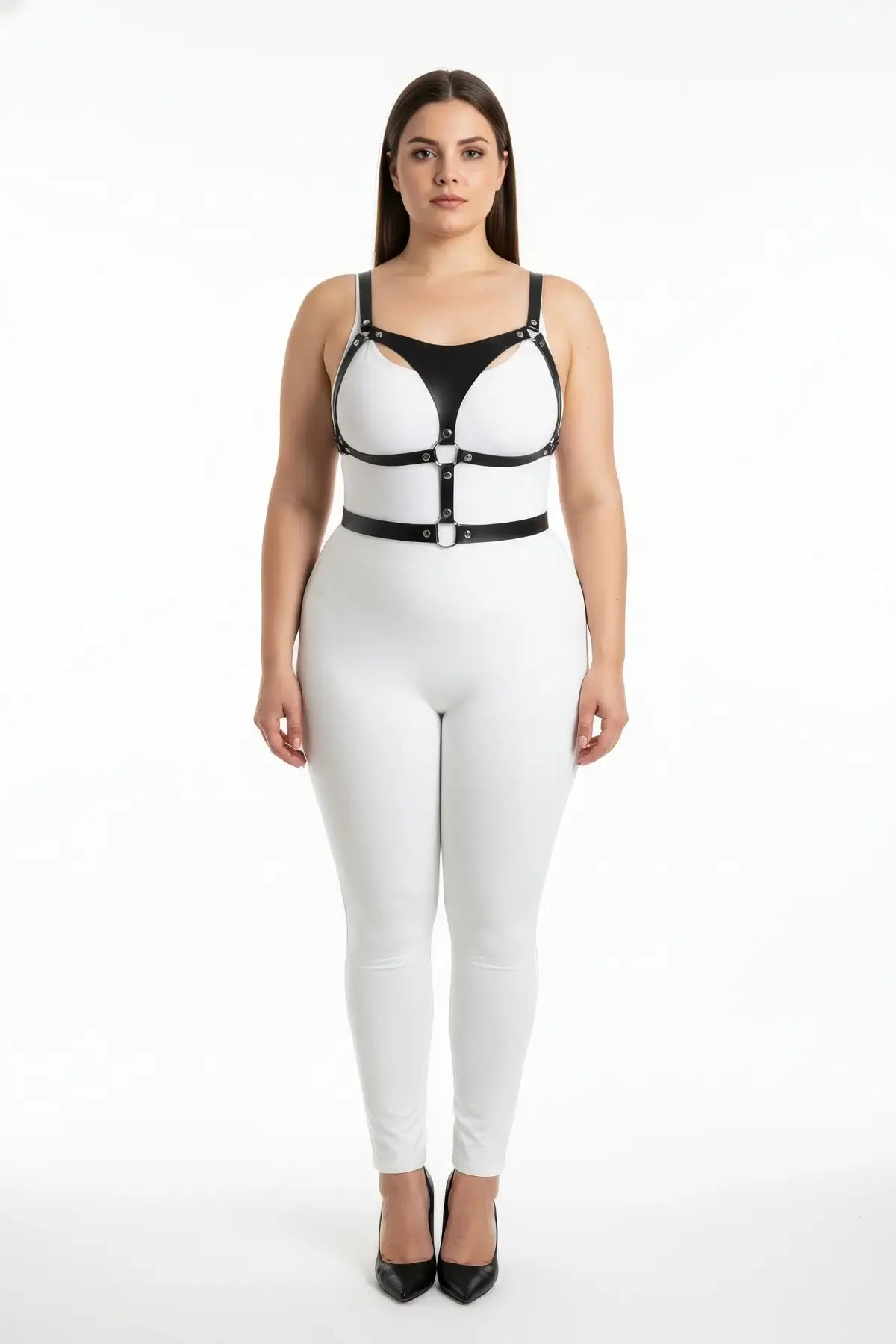 Plus-size black vegan leather chest and waist harness with metal buckles and rings on a model in a white bodysuit