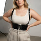 Plus Size Black Shoulder Strap Corset Harness with lace-up front in vegan leather, worn over a cream tank top
