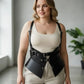 Plus-size black shoulder-strap harness vest in vegan leather with double buckles and peplum waist cincher