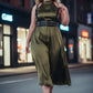 Plus-size black vegan-leather three-band corset harness worn over olive satin dress