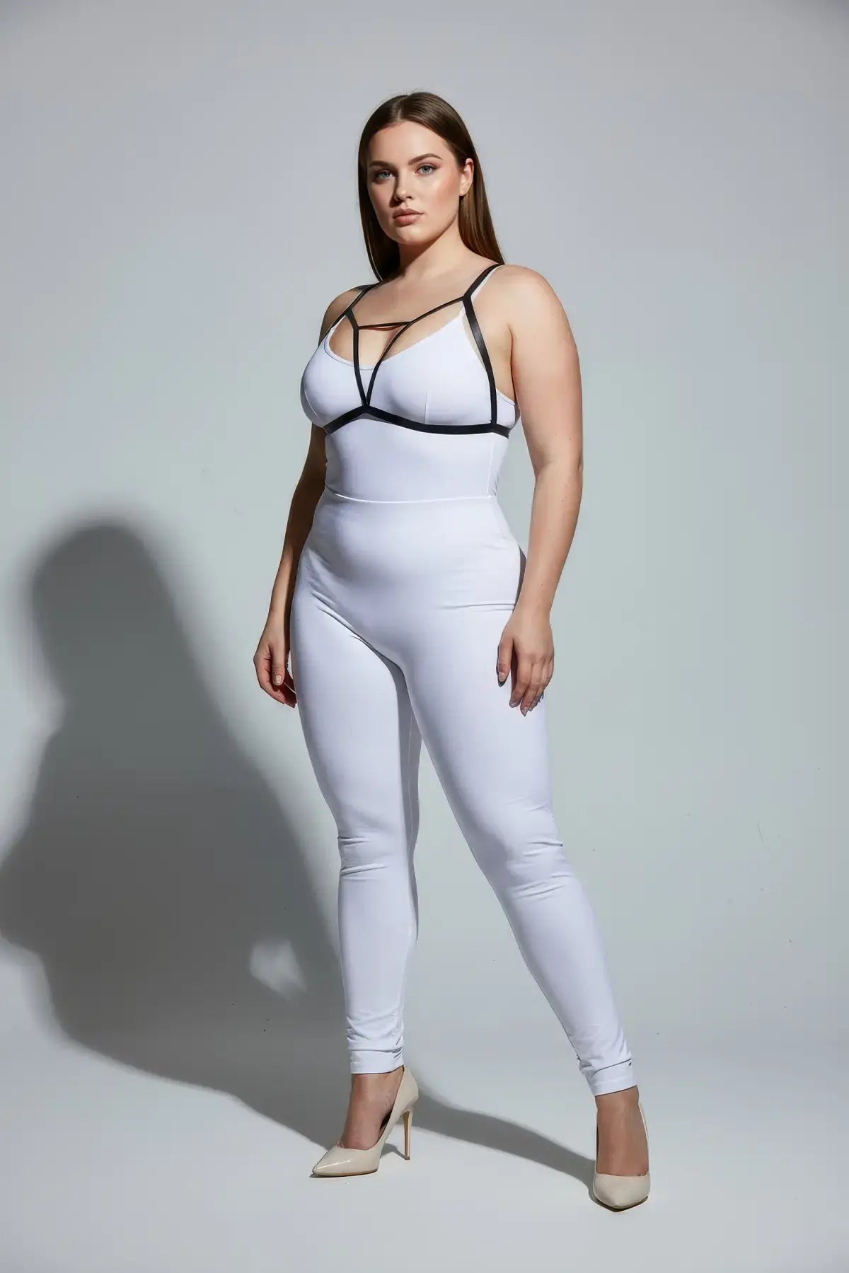 Plus-size black V-strap chest harness with keyhole detail worn over a white bodysuit by HarnessClub