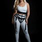 Plus size black vegan leather waist harness with tassel fringe garter worn by model.