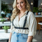 Plus-size black vegan leather shoulder harness with waist belt worn over a light blouse on a smiling model