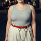 Plus-size burgundy vegan-leather belt with o-rings and chains, worn at the waist