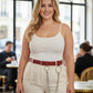 Plus-size burgundy vegan leather slim waist belt with O-rings and chains worn by a model