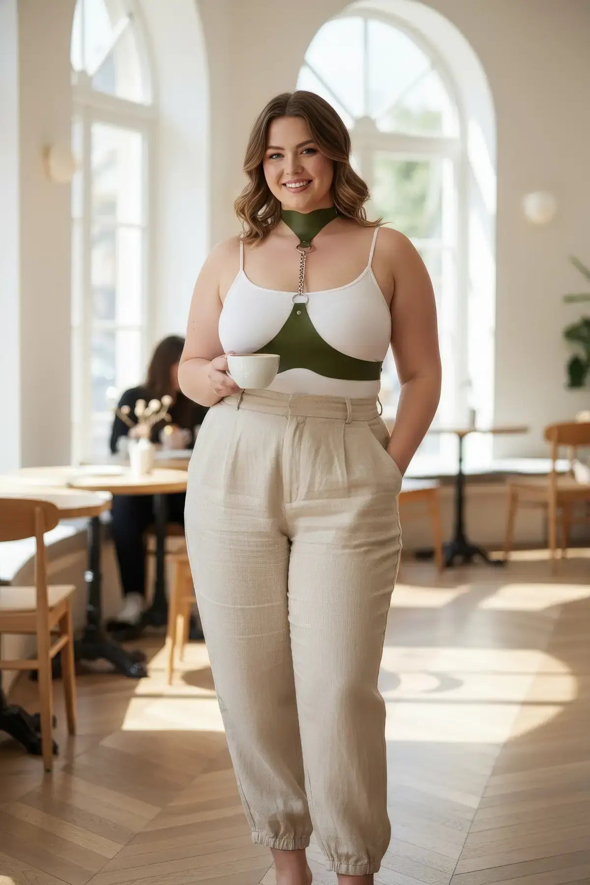 Plus-size chain-detail leather body harness by HarnessClub in olive green, worn over a white top.