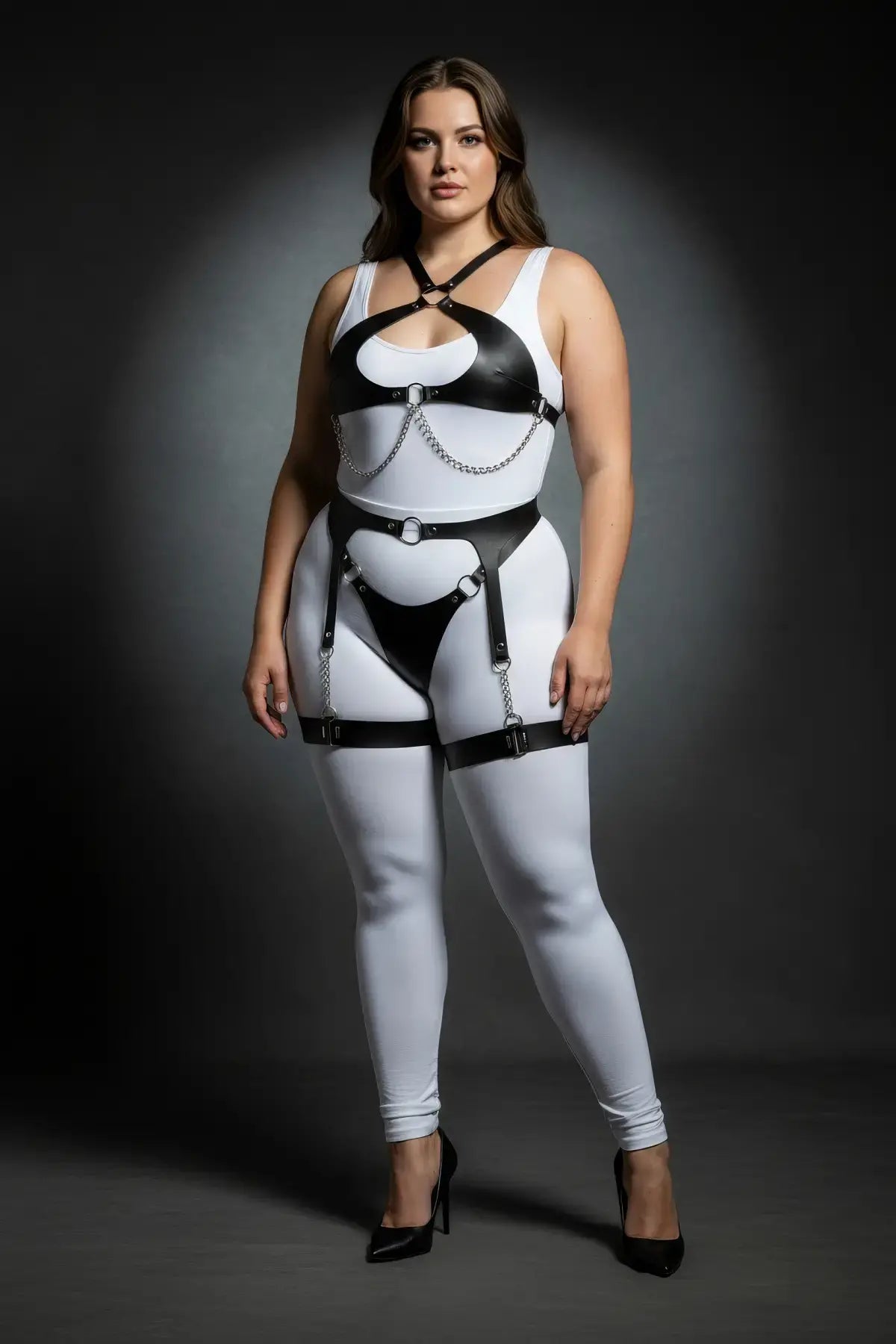 Plus-size chain-draped vegan leather harness set with thong-front hip belt; white bodysuit, black straps, silver chains