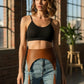 HarnessClub cognac vegan-leather tassel high-waist hip belt worn over jeans.