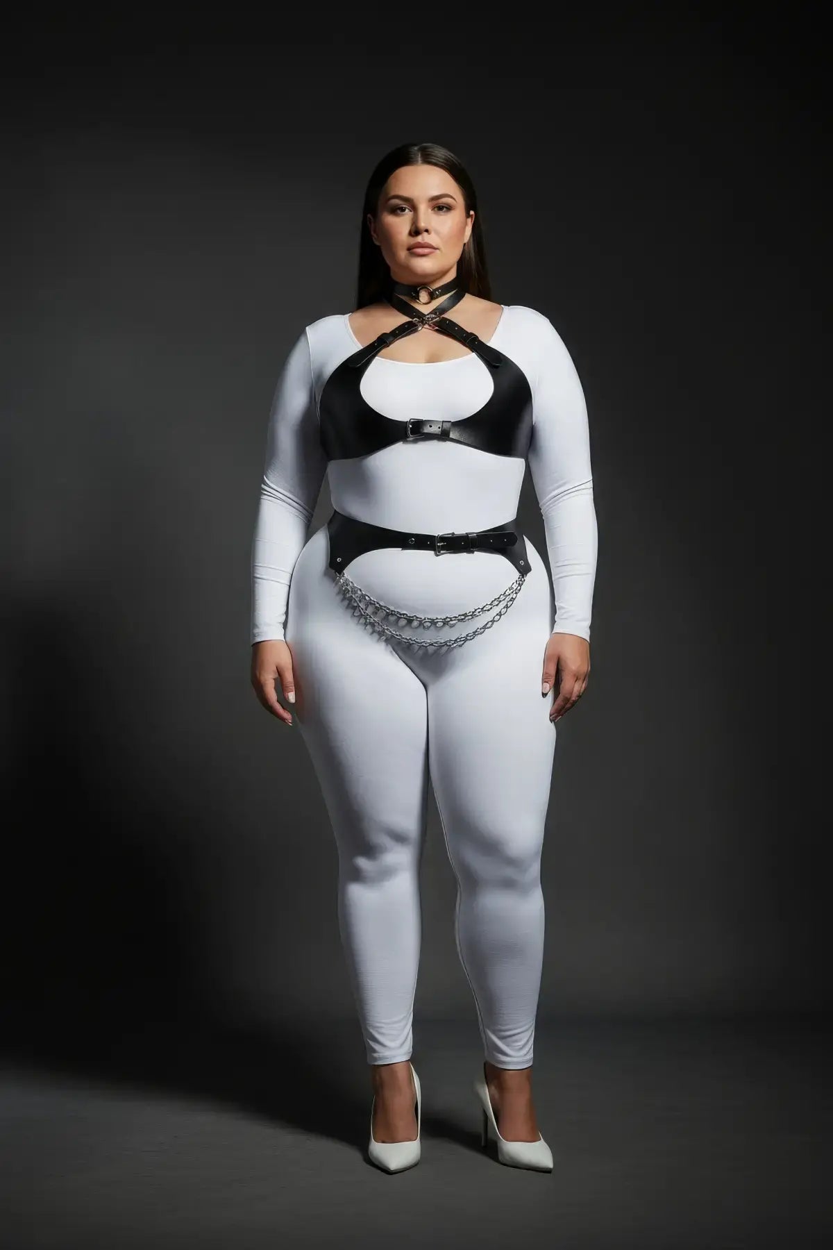 HarnessClub plus-size crossover underbust harness with vegan leather, chain-drape belt worn over white bodysuit.