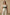Plus-size khaki corset harness with shoulder straps and lace-up front, worn over a white ribbed tank top.