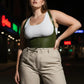 HarnessClub plus-size khaki lace-up corset belt worn over a white tank top