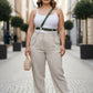 Plus-size khaki leather body belt with chain detail worn at the waist by a model on a city street.