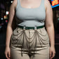 Plus-size khaki vegan-leather slim belt with cascading silver chains worn over beige pants
