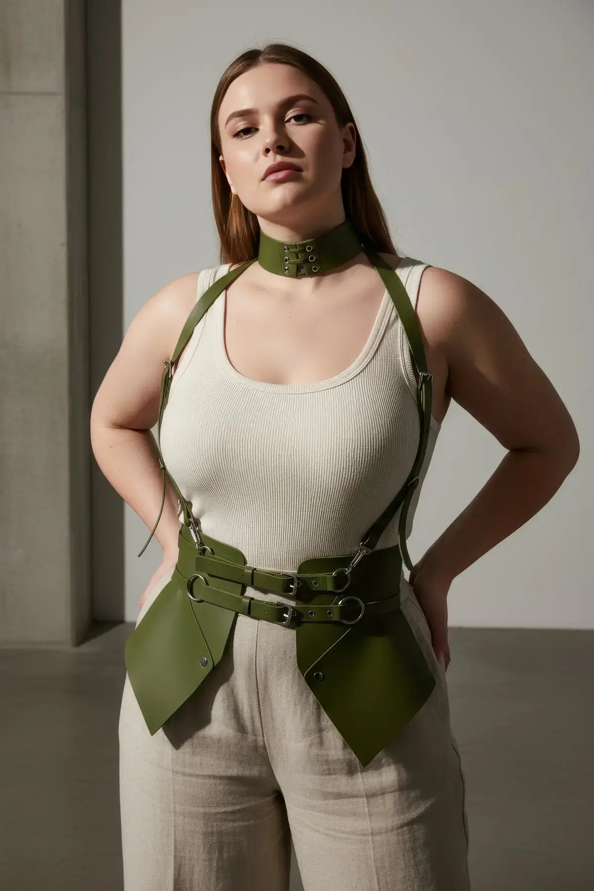 Plus-size khaki vegan-leather suspender corset harness with choker and hip flaps worn over a white tank