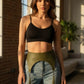 HarnessClub plus-size khaki textured vegan leather corset belt with tassels, worn at the drop waist over denim jeans