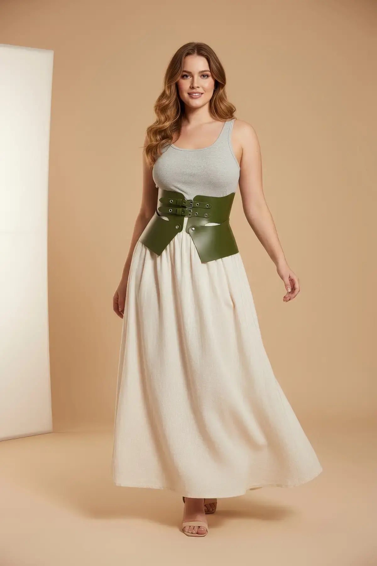 Plus-size khaki vegan leather corset belt by HarnessClub, worn over a cream dress.