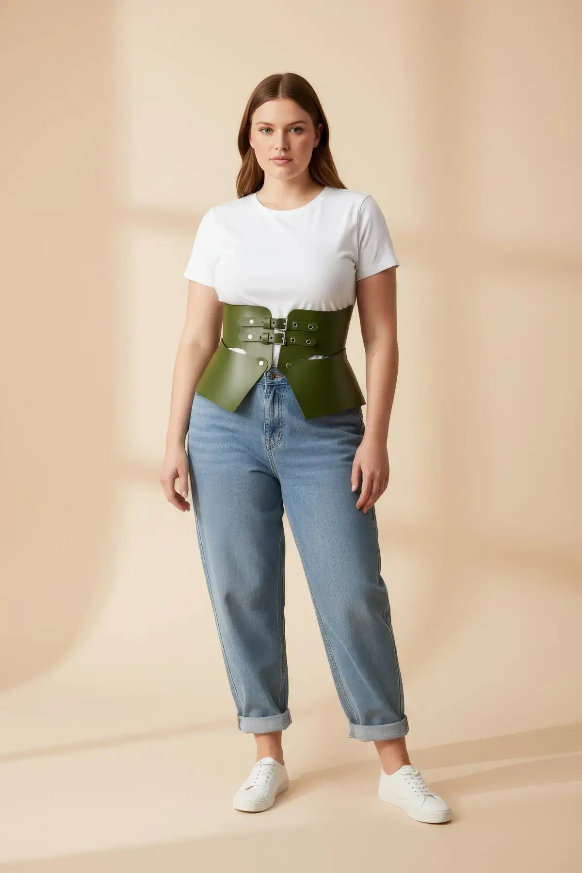 HarnessClub plus-size khaki vegan-leather corset belt, wide structured waist piece worn over a white tee and jeans.